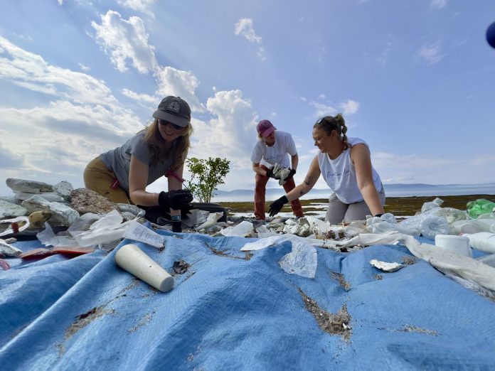 3 femmes ramassent des plastiques sur une plage