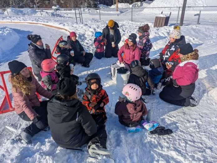 jeunes assis dans la neige au soleil