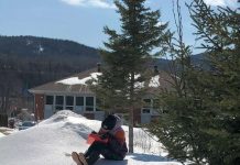 un jeune écrit assis sur la neige