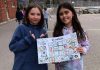 Deux jeunes filles nous montrent une pancarte sur le tri sélectif