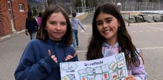 Deux jeunes filles nous montrent une pancarte sur le tri sélectif
