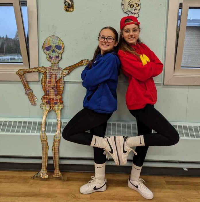Deux jeunes filles nous regardent dos à dos le sbras croisés