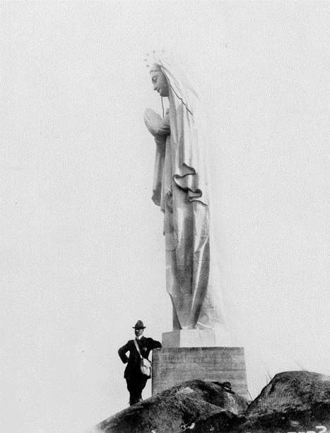 Image1 Un homme tout petit se tient au pied de la Statue Notre-Dame-du-Saguenay.