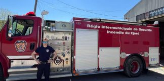 Un pompier pose fièrement devant le camion de l RISIF à Sant-Félix-d'Otis